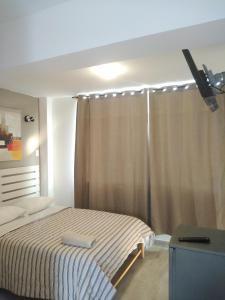 a bedroom with a bed and a window with a curtain at Hospedaje Nuna - Playa Huanchaco in Huanchaco