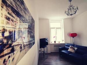 a living room with a blue couch and a large painting at Apartma MB-Center in Maribor
