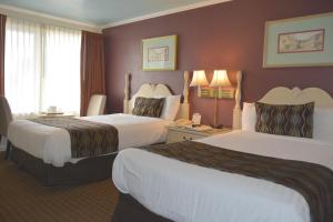 Habitación de hotel con 2 camas y ventana en Oasis Inn and Suites en Santa Bárbara