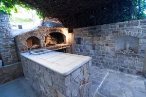 una cucina esterna in pietra con forno in pietra di Apartments Radić a Bol
