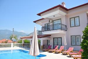 a villa with a swimming pool and patio furniture at Villa Ahad in Fethiye