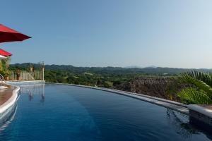 a swimming pool with a view of the mountains at Villa Bella Bed & Breakfast Inn in Cruz de Huanacaxtle