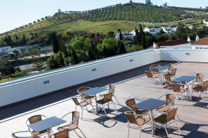 a patio with tables and chairs on a roof at Flag Hotel Villa Aljustrel in Aljustrel