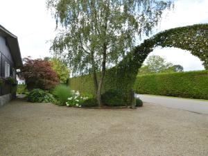 ein Torbogen mit einem Baum im Hof in der Unterkunft Elegant Chalet in Malmedy with Private Garden in Malmedy