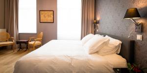 een slaapkamer met een groot bed met witte kussens bij B&B Avenue Deschanel in Brussel