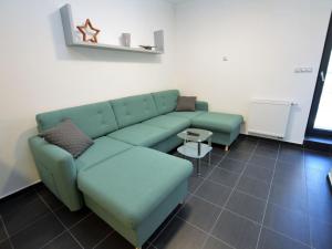 uma sala de estar com um sofá verde e uma mesa em Quaint Holiday Home in elezn Ruda near Ski Area em Železná Ruda