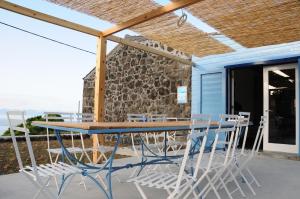 a blue table and chairs on a patio with the ocean at Casas das Portas do Mar e das Portas do Sol in São Roque do Pico