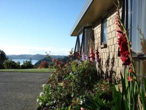 a house with flowers on the side of it at Ohuka Place Homestay in Whitianga