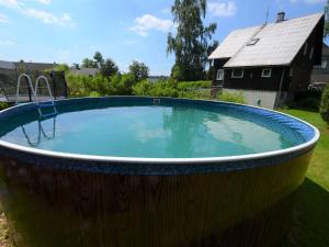 uma grande piscina numa banheira de madeira num quintal em Holiday home in Star K e any with fenced garden em Staré Křečany