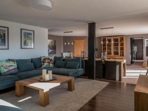 ein Wohnzimmer mit einem blauen Sofa und einem Tisch in der Unterkunft Leuk huis met zwembad in Cetturu
