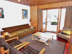 een woonkamer met een bank, stoelen en een tafel bij Apartment only approx 60m from the ski lift in La Tzoumaz