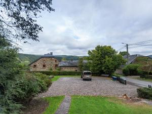 a van parked in the driveway of a house at Charming Cottage in Stoumont with colourful garden in Exbomont