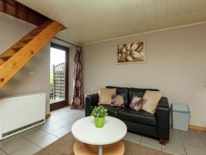 a living room with a couch and a table at Charming Cottage in Stoumont with colourful garden in Exbomont