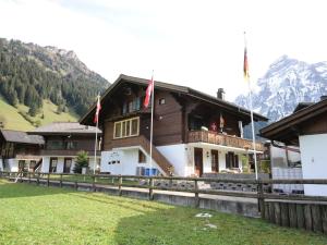 un edificio con dos banderas a un lado en apartment in Lenk in Simmental Bernese Oberland, en Lenk