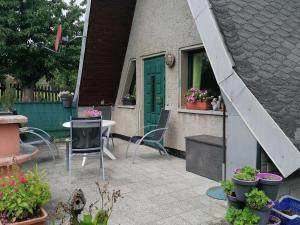 un patio con mesa, sillas y macetas en Holiday Home in H ttenrode with private terrace, en Hüttenrode
