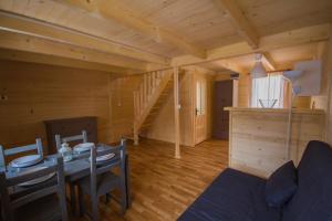 a living room with a table and a staircase in a cabin at Holiday Resort & Camping InterCamp'84 in Łeba