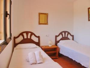 Un dormitorio con 2 camas y una mesa con toallas. en Bungalow La Joya, en Benitachell