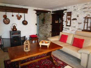 - un salon avec un canapé et une table dans l'établissement Beautiful and Authentic Cottage, à Houffalize