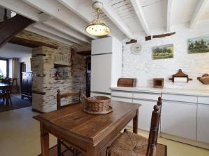 cocina con mesa de madera y pared de piedra en Beautiful and authentic cottage in the heart of the Ardennes, en Houffalize