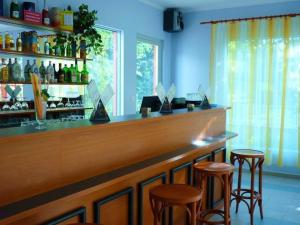 a bar with stools in a room with blue walls at Pergola Panzió in Balatonföldvár