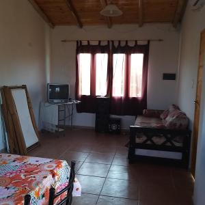 Habitación con cama, TV y ventana. en Cabaña 508km en San Rafael