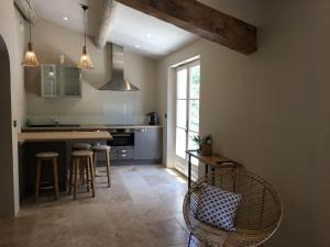 EyraguesにあるModern holiday cottage with swimming pool and close to beautiful Saint Remy de Provenceのキッチン(カウンター、いくつかの椅子付)