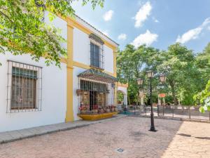 ein gelbes und weißes Gebäude mit Straßenbeleuchtung in der Unterkunft Modern Villa in Priego de Cordoba with Private Pool in Priego de Córdoba