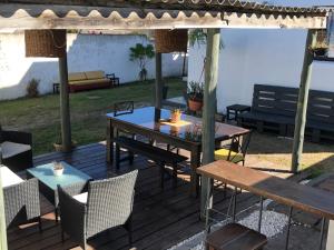 a wooden deck with a table and chairs at Casa Estrella de Mar in La Paloma