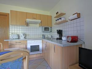 uma pequena cozinha com armários de madeira e electrodomésticos brancos em Apartment near the ski area in Diemelsee em Diemelsee