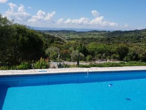 a blue swimming pool with a view of the countryside at Stylish villa with private pool in Félines-Minervois