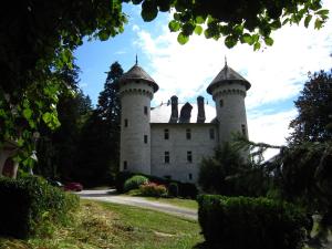 a castle with two towers on top of it at Cosy castle with pool in Serrières-en-Chautagne
