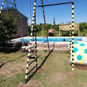 un columpio frente a una piscina en Cabaña 508km en San Rafael