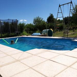 una persona nadando en una piscina en un patio trasero en Cabaña 508km en San Rafael
