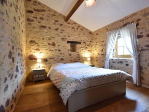 1 dormitorio con 1 cama en una habitación con paredes de piedra en Luxury house in Aquitaine with swimming pool, en Saint-Avit-Rivière