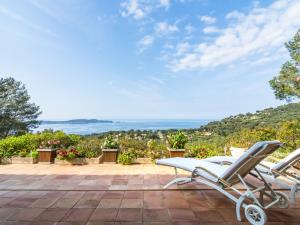 a pair of chairs on a patio with a view of the ocean at Pretty house with sea view on the Hy res in Hyères
