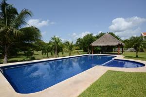 a swimming pool in a yard with a gazebo at B&B Mom's House in Puerto Aventuras