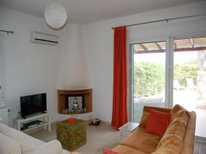 a living room with a couch and a television at Enticing Villa in Loutra with Private Pool in Loutra