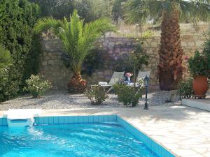 a swimming pool in a yard with palm trees at Enticing Villa in Loutra with Private Pool in Loutra