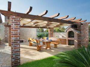a patio with a wooden pergola and a table at Lovely holiday home in Fazana with swimming pool in Štinjan