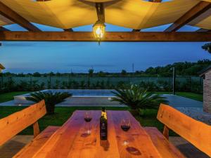 a wooden table with two glasses of wine on it at Lovely holiday home in Fazana with swimming pool in Štinjan
