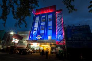 a building with blue and red lights on it at Cordela Hotel Medan in Medan