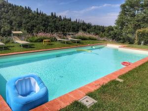 una piscina con una silla azul en el césped en Belvilla by OYO Podere Pulicciano Cantina, en Pian di Scò