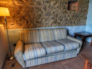 un sofá en una sala de estar con una pared de piedra en Belvilla by OYO Podere Pulicciano Cantina, en Pian di Scò