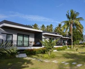 a house with palm trees in front of it at DANUP VILLA in Wok Tum