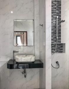 ein Bad mit einem Waschbecken und einer Dusche mit einem Spiegel in der Unterkunft DANUP VILLA in Wok Tum