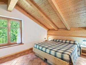 ein Schlafzimmer mit einem Bett und einer Holzdecke in der Unterkunft Belvilla by OYO Il melo bianco in Caldes