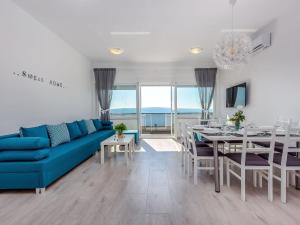 Una sala de estar con un sofá azul y un comedor. en Apartment in Croatia by the Seafront, en Dramalj 32 fotos más