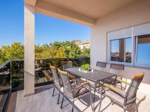 Un patio con una mesa y sillas en un balcón. en Apartment in Croatia by the Seafront, en Dramalj
