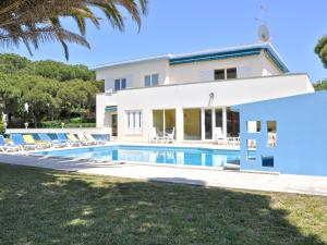 a villa with a swimming pool in front of a house at Spacious Villa in Vilamoura with Barbecue in Vilamoura