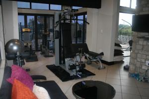 een fitnessruimte met een fitnessruimte met een simulator bij Africa Paradise - OR Tambo Airport Boutique Hotel in Benoni